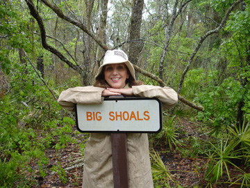 Karen Duquette at the Big Shoals sign in the woods