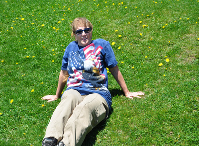 Karen Duquette relaxing in a grassy field of wildflowers