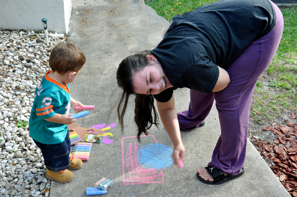 Anthony and his mother chalking the sidewalk
