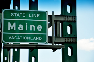 Maine's state line sign on the bridge