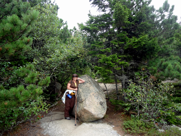 Karen Duquette rests at a big boulder encountered along the trail.