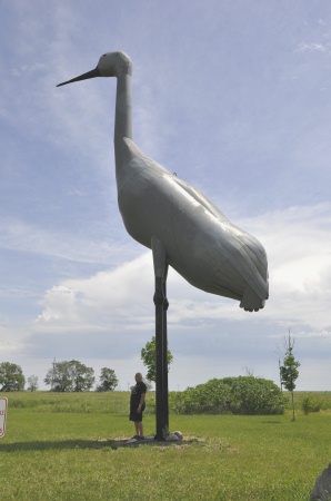 Lee Duquette stands by the World's Largest Sandhill Crane statue 