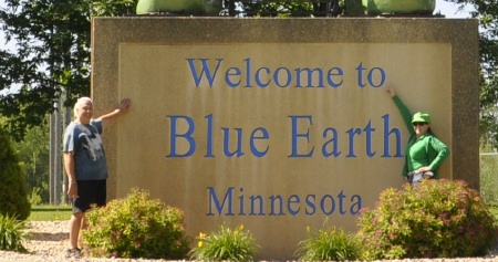 The two RV Gypsies by a Welcome to Blue Earth Minnesota sign