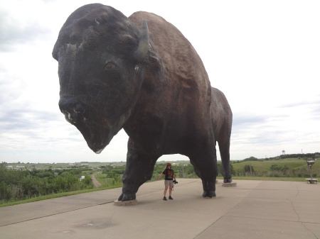 Karen Duquette standing under the World's Largest Buffalo statue
