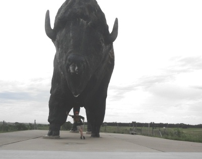 Karen Duquette leaning on the World's Largest Buffalo statue
