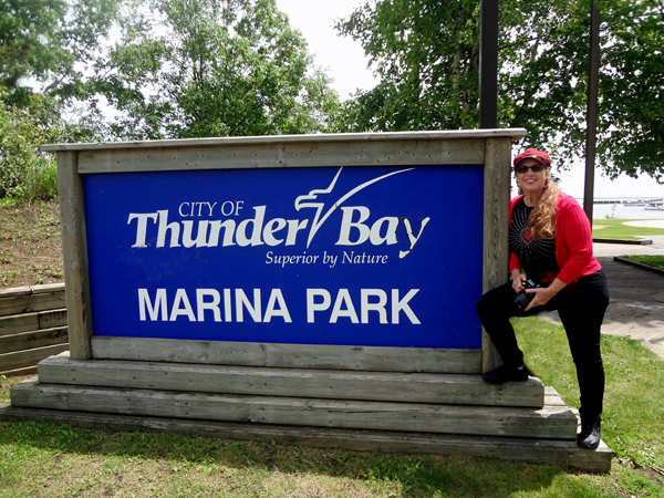 Karen Duquette at the Thunder Bay Marina Park sign