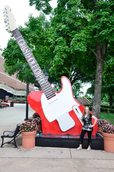 Karen Duquette by a guitar at the entrance to Grand Ole Opry