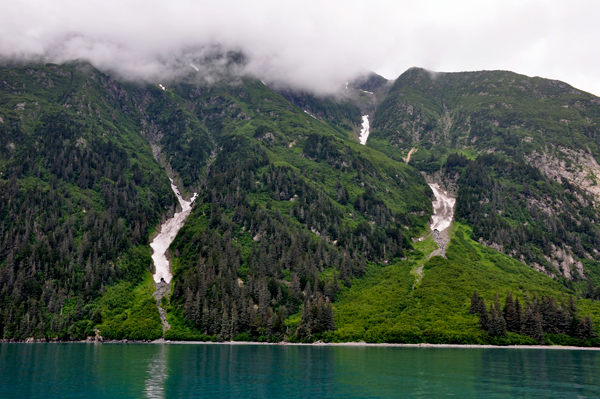 mountains covered with cliffs, waterfalls, and patches of snow