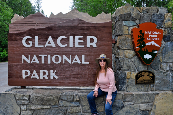 Karen Duquette at the Glacier National Park sign