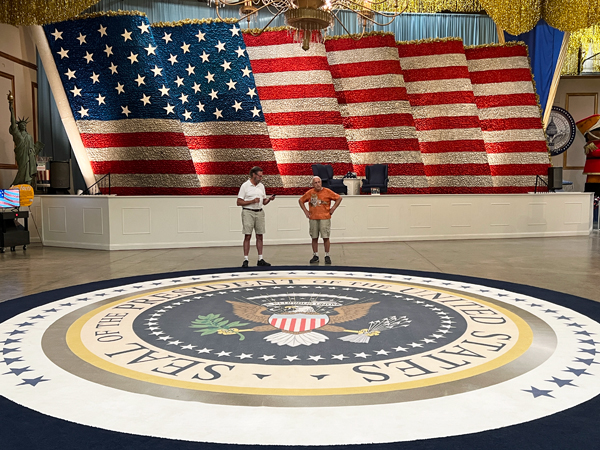 Lee Duquette and the guide by the giant USA flag float