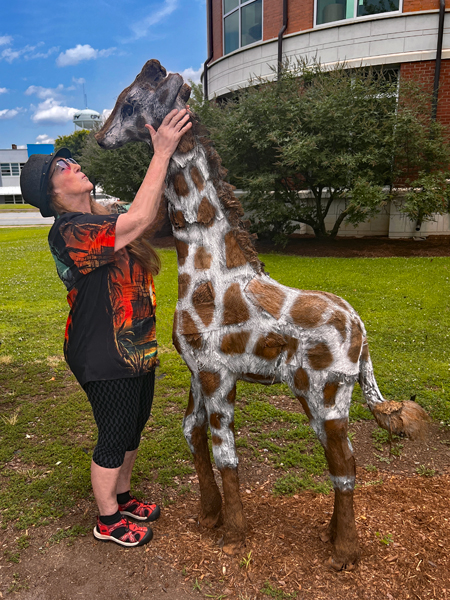 Karen Duquette gave the baby giraffe a loving kiss