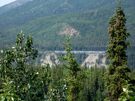 a train travels along the beautiful mountain's edge