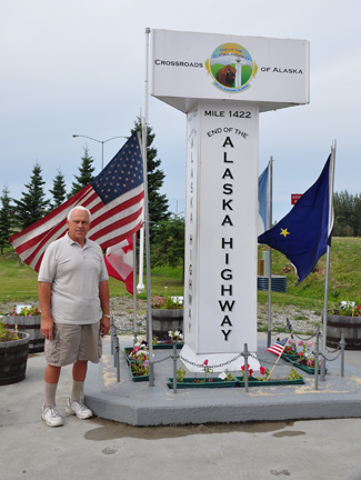 Lee Duquette and the large white milepost for Mile 1422 of the Alaska Highway