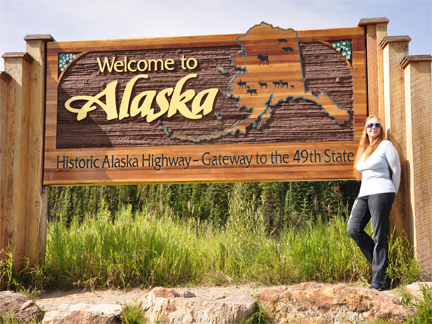 Karen Duquette and  a welcome to Alaska sign
