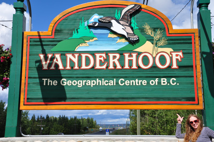 Karen Duquette and a sign - welcome to Vanderhoof BC