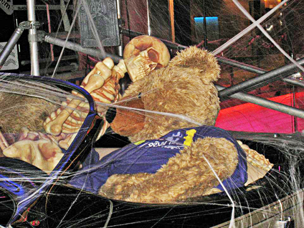 Teddy Bear driving the car with his skeleton passenger.