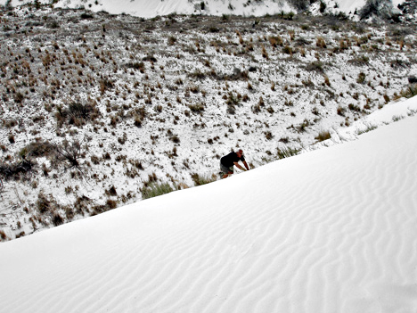 Lee Duquette climbing up the white sand dune