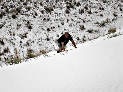 Lee Duquette climbing up the white sand dune