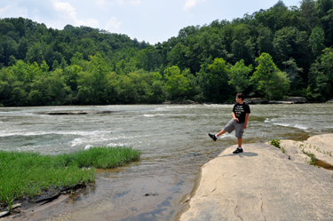 Alex throwing a small stick into the Cumberland River.