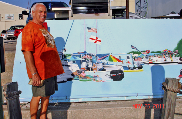 Lee Duquette a beside hand painting on the dock