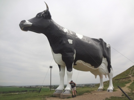Karen Duquette leans against the World's Largest Holstein cow