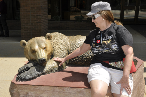 Karen Duquette pets a sleeping Grizzly Bear sculpture