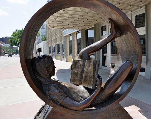 Girl in a circle reading a book sculpture