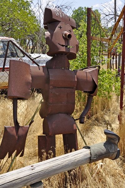 a tin man by a post with a cowboy boot