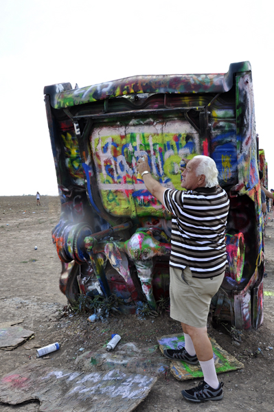 Lee Duquette spray painting a caddy at Cadillac Ranch
