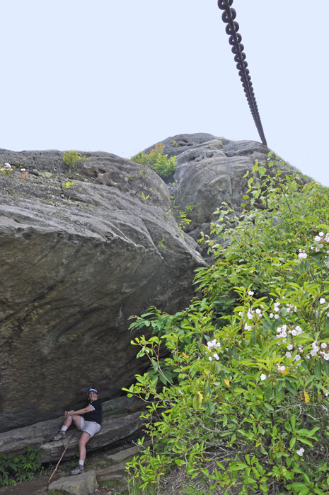 Karen Duquette sitting on a ledge under one of the big boulders.