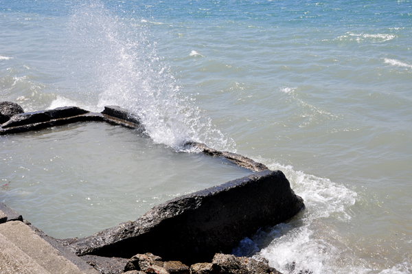 Karen Duquette photographs the waves breaking over the seawall