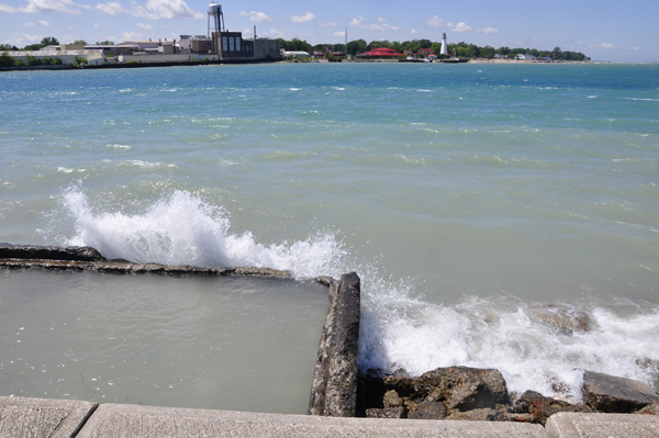 Karen Duquette photographs the waves breaking over the seawall
