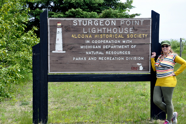 Karen Duuette at the Sturgeon Point Lighthouse sign