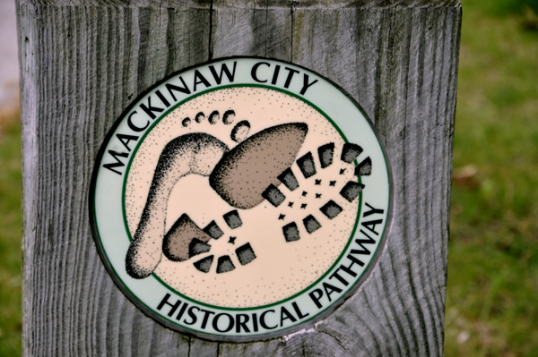 sign on a stump: Mackinaw City Historical Pathway