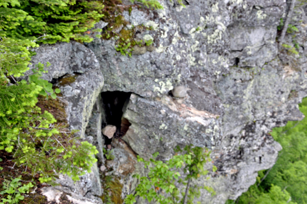 a big hole in the cliff with?one lone rock inside the hole