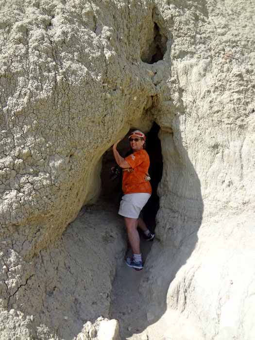 Karen Duquette peeks into the cave at Castle Butte