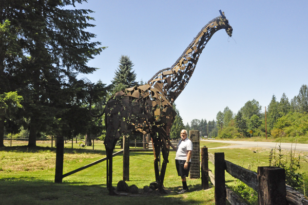 Lee Duquette by a giant giraffe sculpture