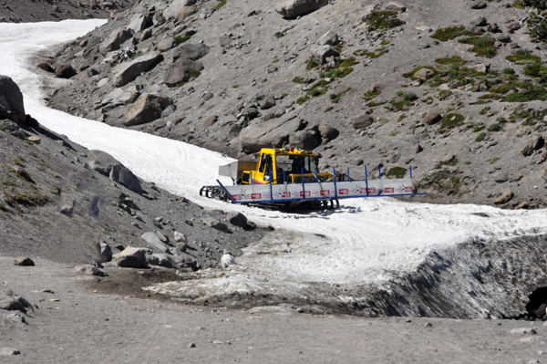 A big machine bringing a snowboard platform down the hill