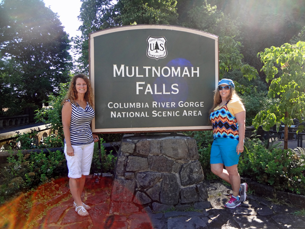 Karen Duquette and her sister Ilse at the Multnomah Falls sign