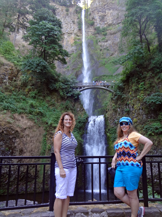 Karen Duquette and her sister Ilse with Multnomah Falls and the footbridge behind them.