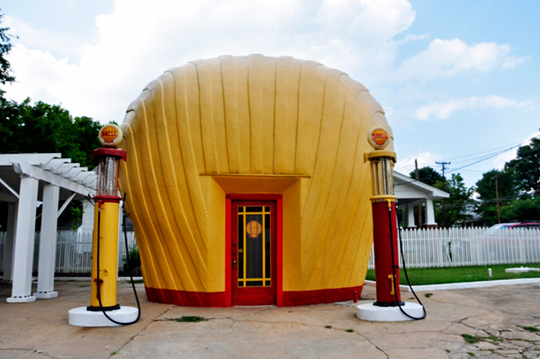 yellow-orange concrete clamshell-shaped  gas station