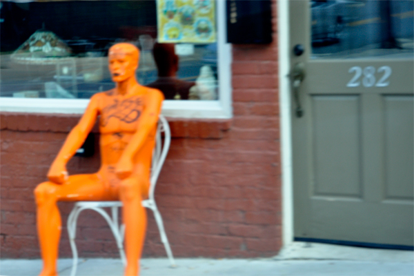 A big, naked, tattooed, orange man