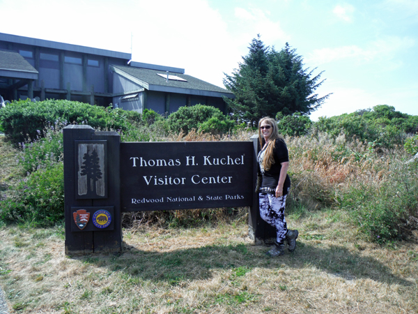 Karen Duquette at the welcome center sign