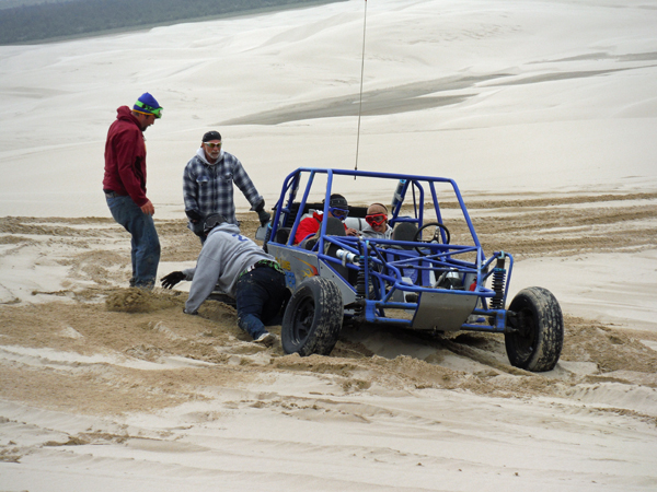 The drivers digging out sand from around the tires.