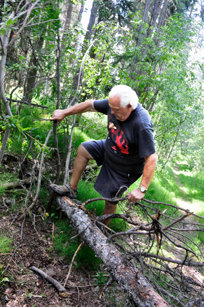 Lee Duquette climbing over the fallen tree