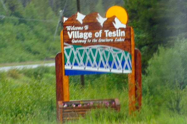 a blurry welcome to Teslin sign