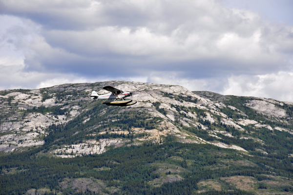 a float plane flying over the mountain