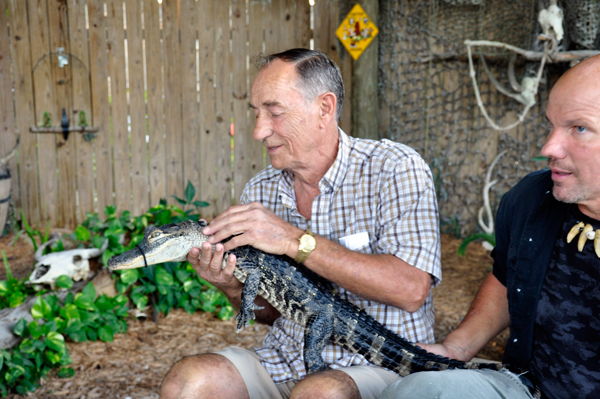 Terry Dickerson  holding a baby alligator.