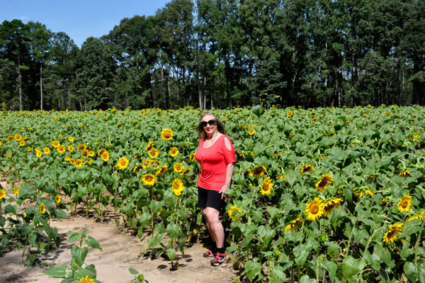 Karen Duquette in a field of sunflowers