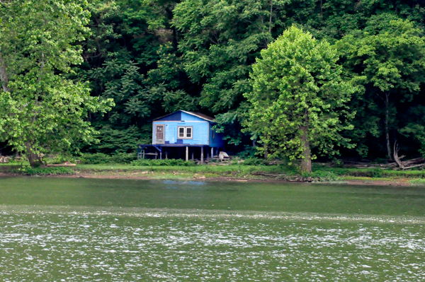a blue cabin across the river